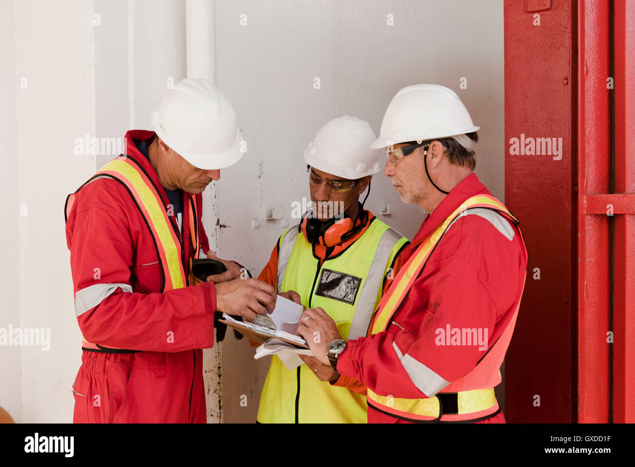 Engineers in brainstorming session on oil rig Stock Photo - Alamy