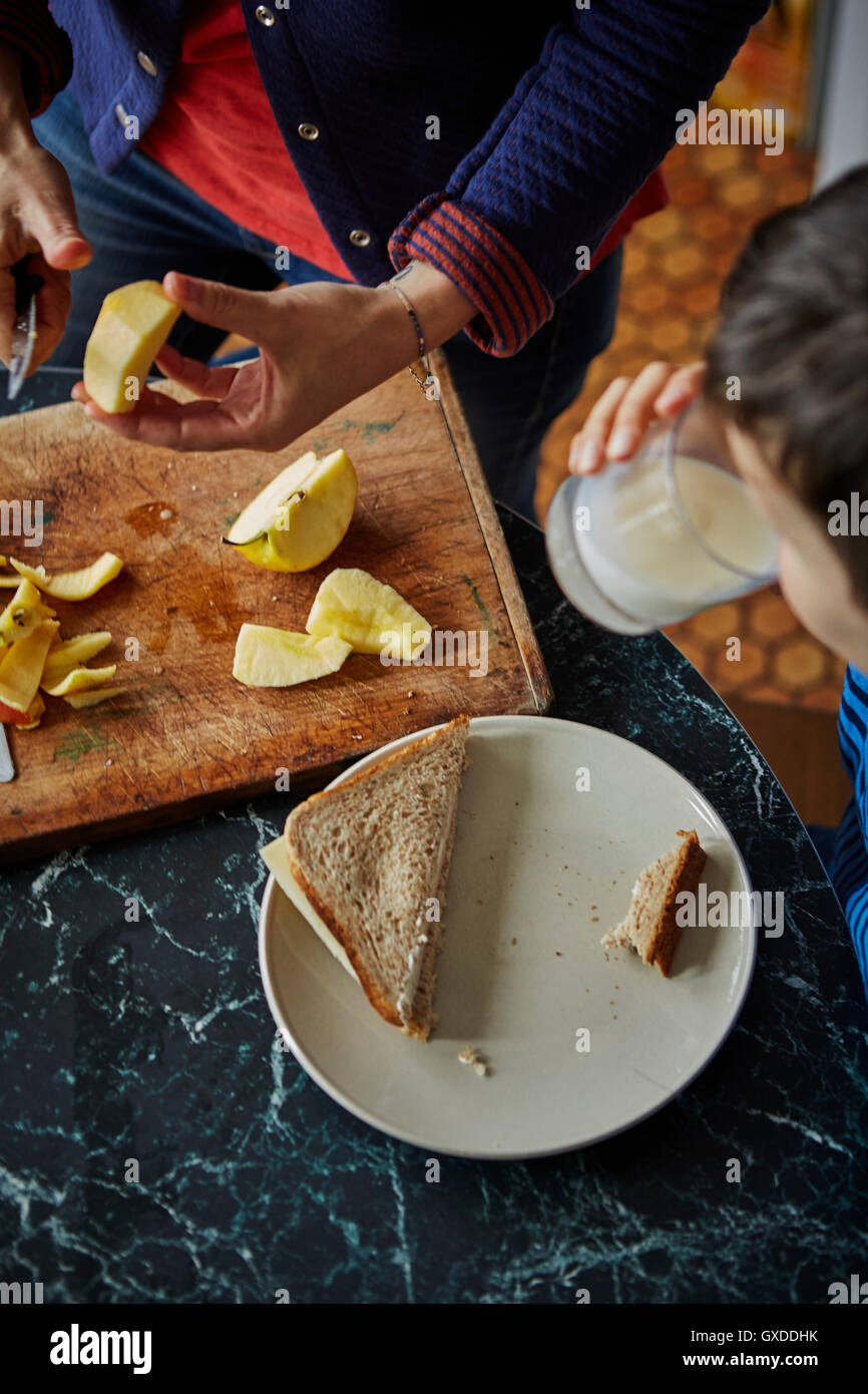 Cropped view of woman chopping apple for son's lunch Stock Photo