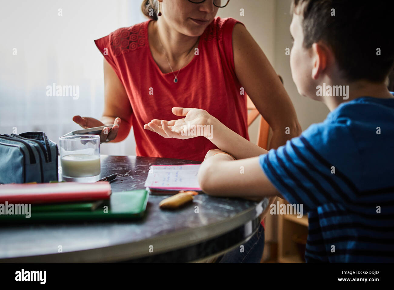 Mother and son at dining table having discussion Stock Photo