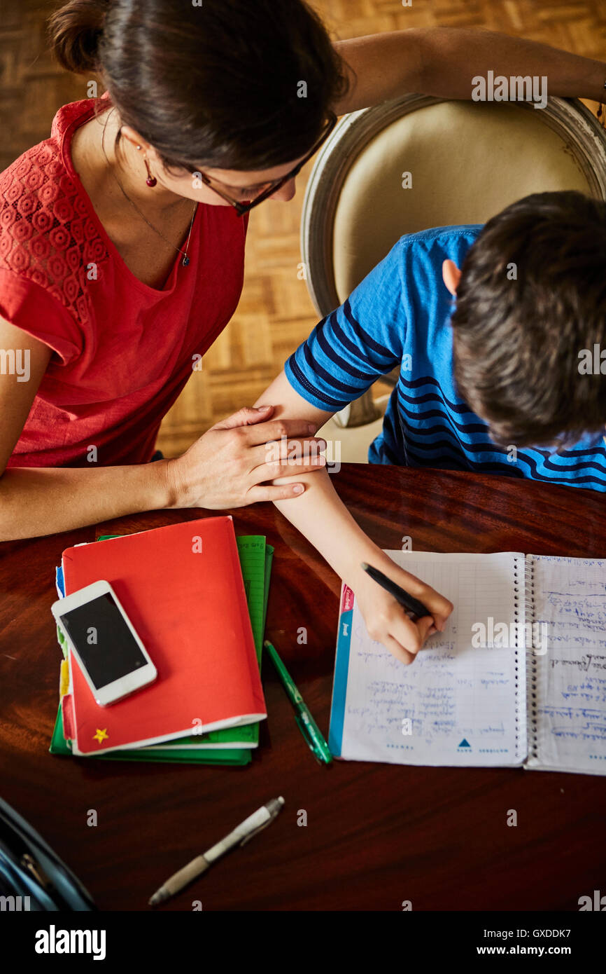 High angle view of mother at dining table helping son with homework Stock Photo