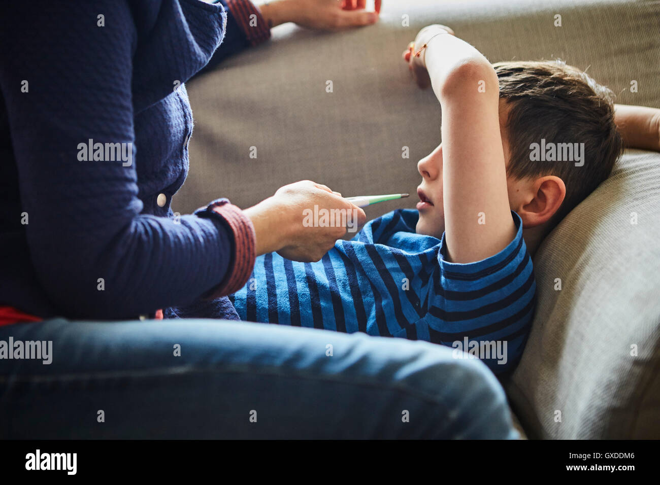 Mother taking son's temperature with digital thermometer Stock Photo