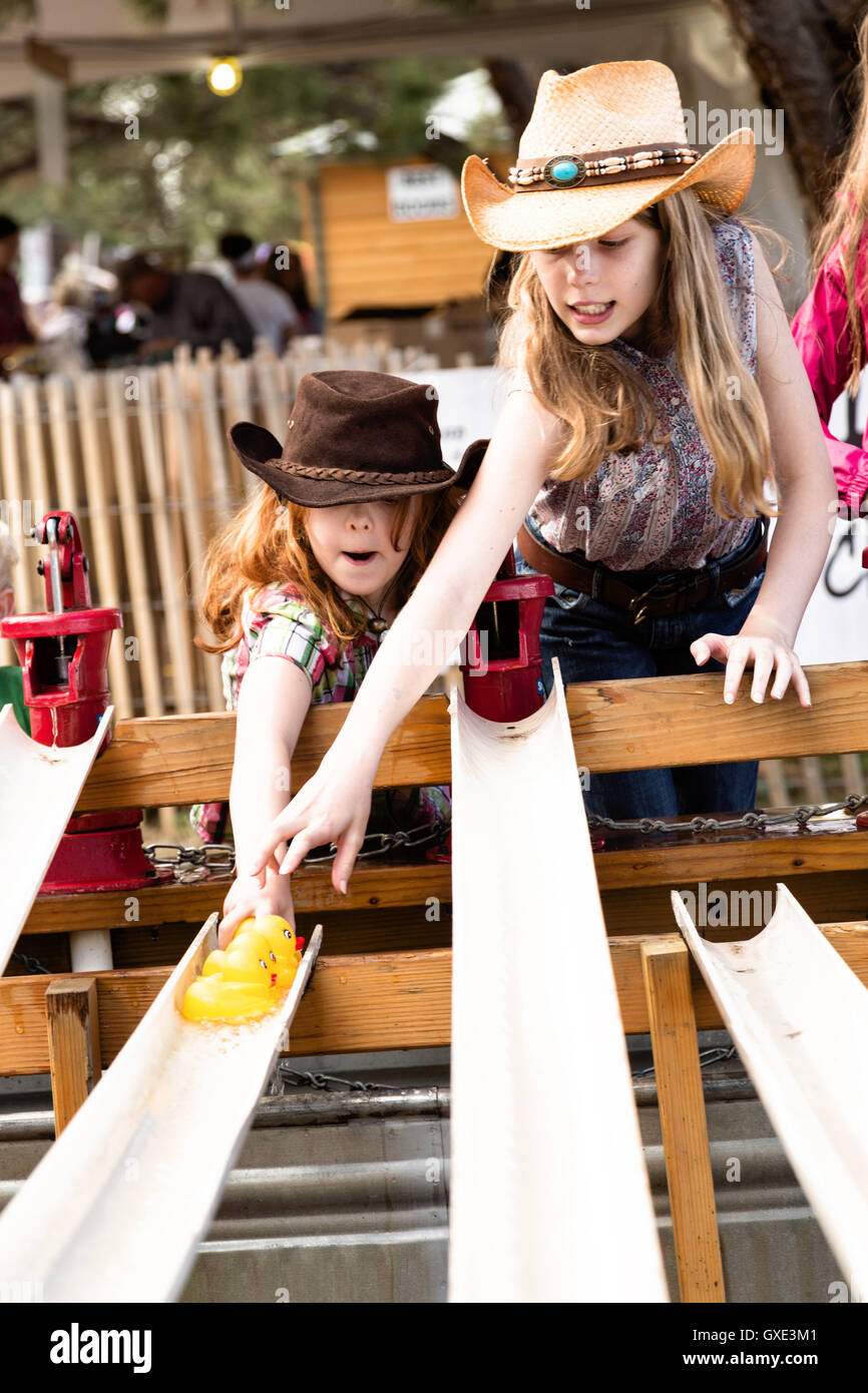 Children wearing cowboy hats race rubber ducks in game during Cheyenne Frontier Days July 22, 2015 in Cheyenne, Wyoming. Frontier Days celebrates the cowboy traditions of the west with a rodeo, parade and fair. Stock Photo