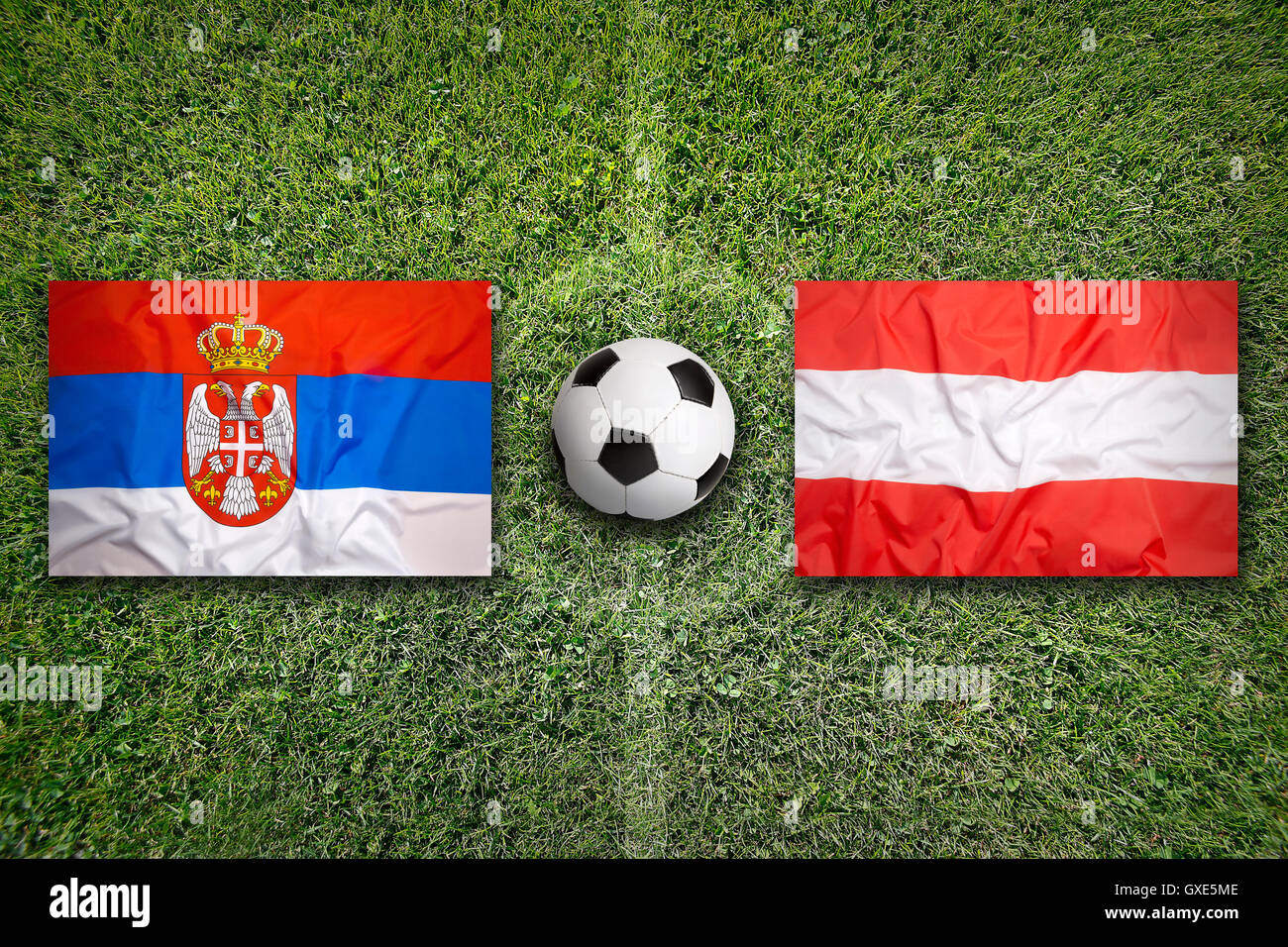 Serbia and Austria flags on a green soccer field Stock Photo