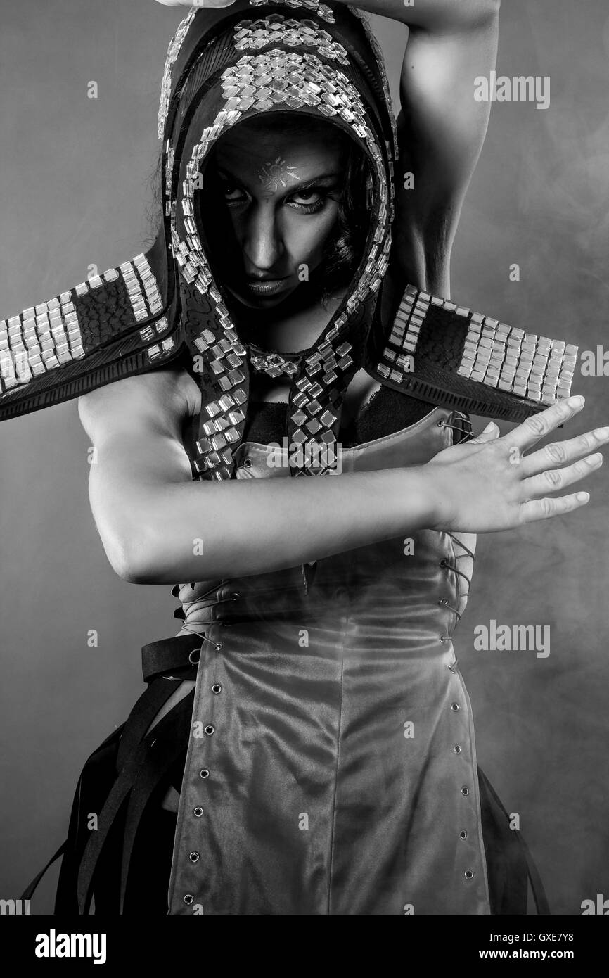 Strong dance, Beautiful brunette woman in armor formed by mirror Stock Photo