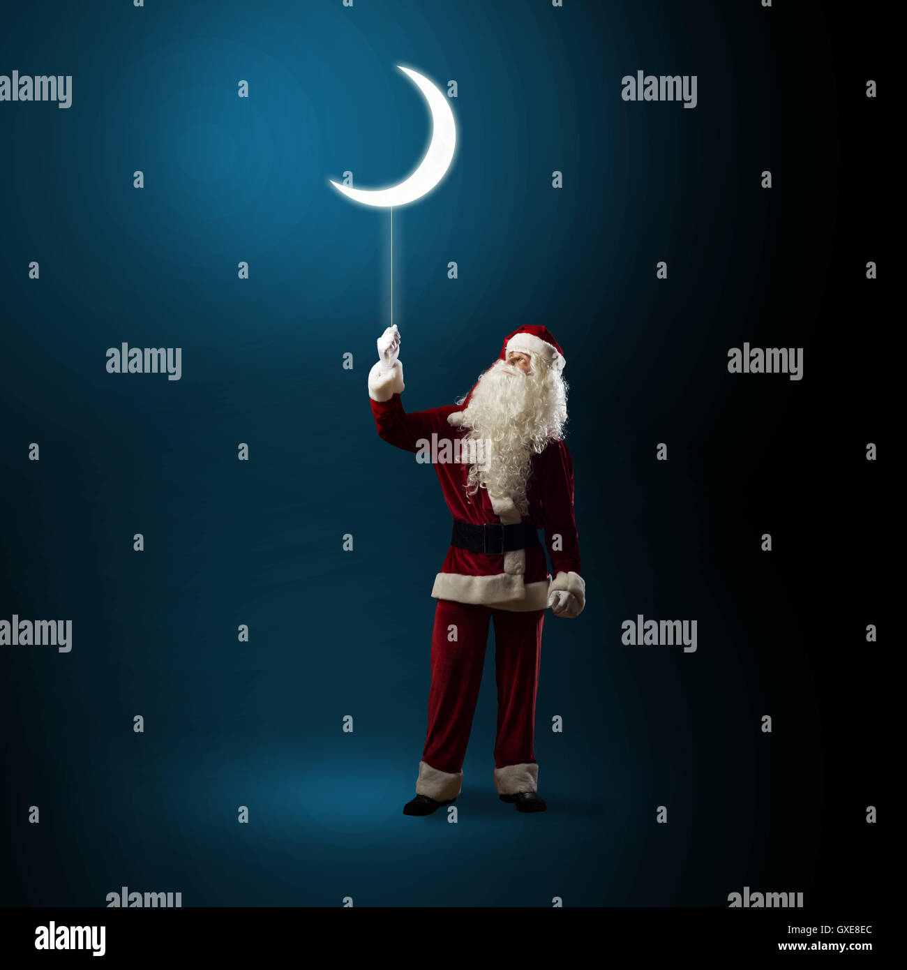 Santa Claus holding a shining moon Stock Photo