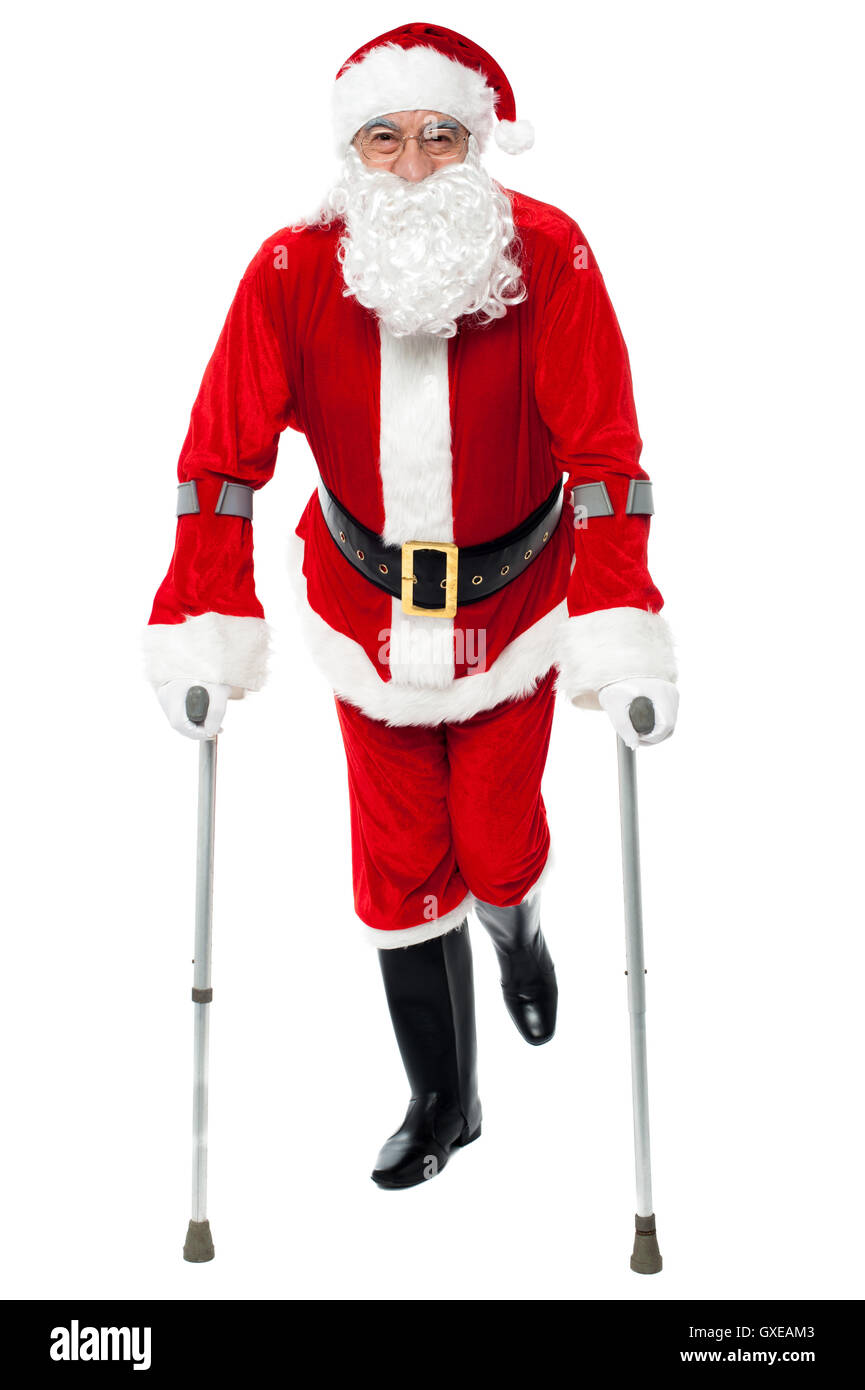 Santa walking with the help of crutches Stock Photo