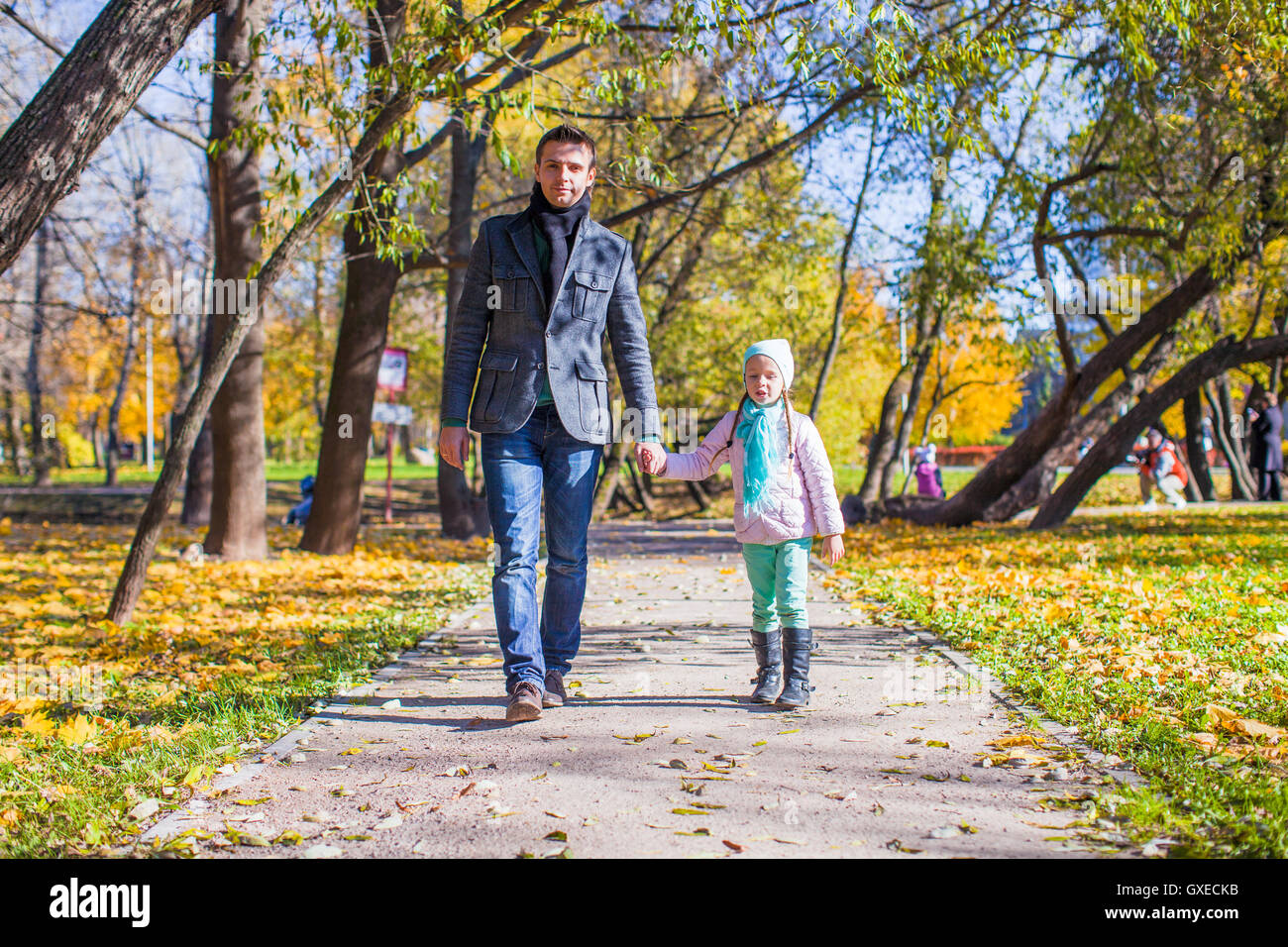 Adorable little girl with happy father walking in autumn park on a ...