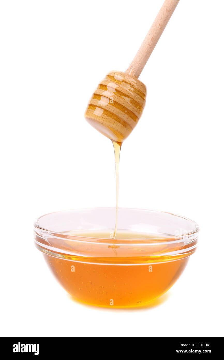 Honey dripping from a wooden dipper. Stock Photo