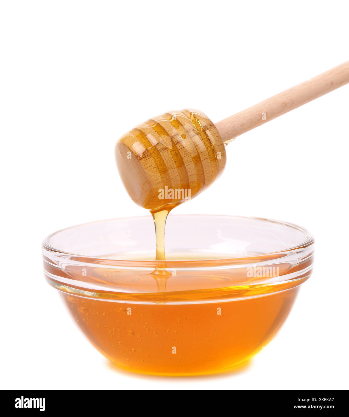 Honey dripping from a wooden dipper. Stock Photo