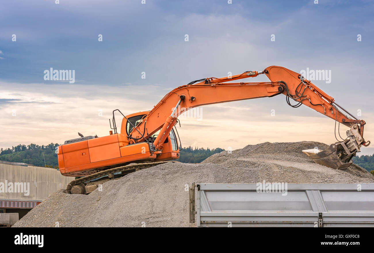 Excavator loading ballast in a trailer Stock Photo Alamy