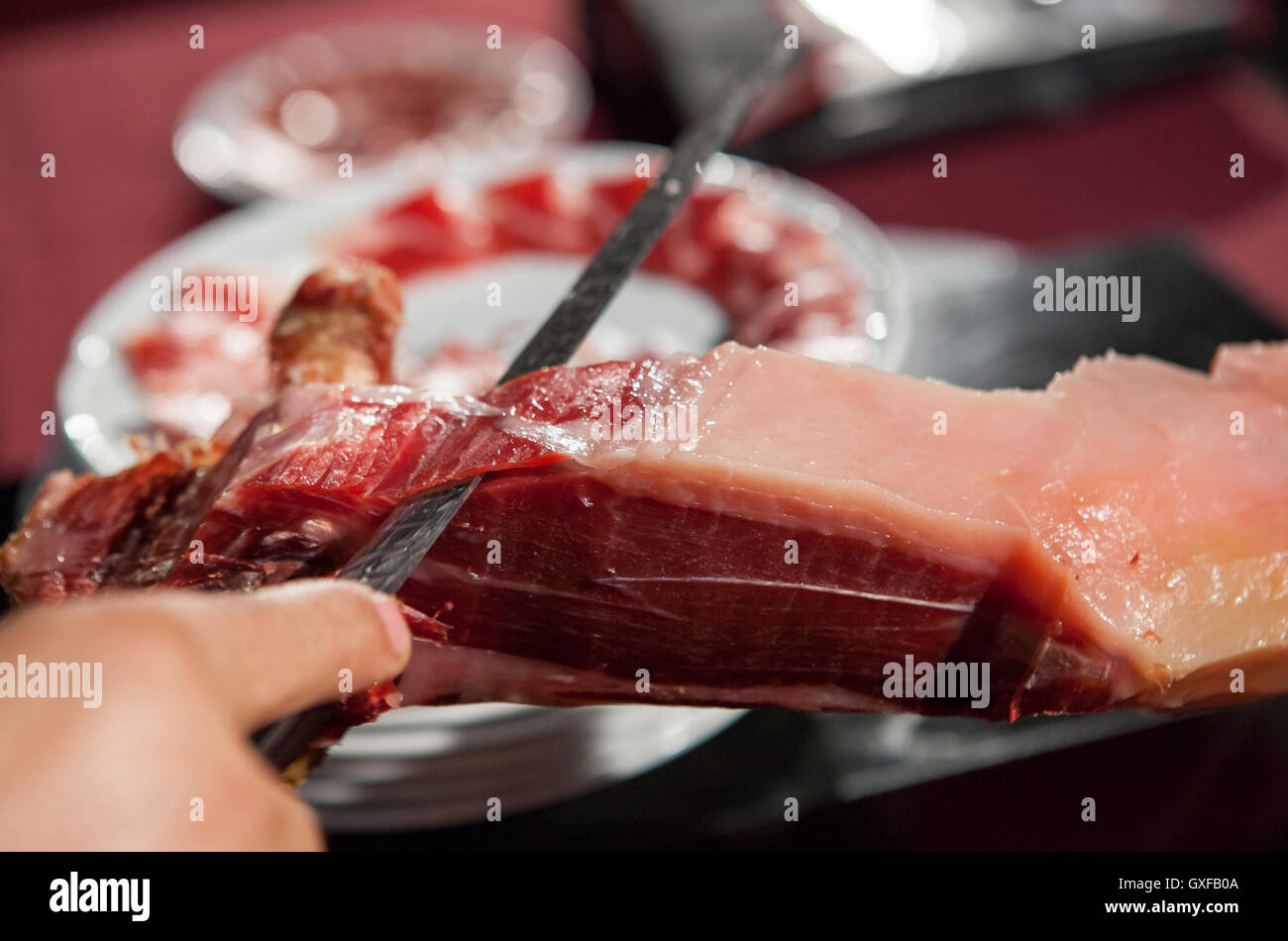 Master slicer cutting iberian cured ham. Selective focus point Stock Photo