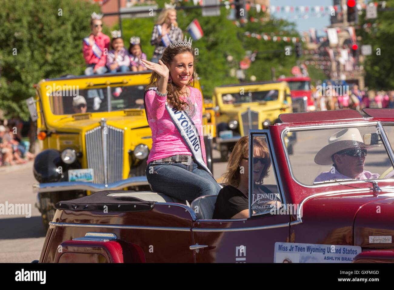 Beauty Queens wave from old buses during the Cheyenne Frontier Days parade past the state capital building July 23, 2015 in Cheyenne, Wyoming. Frontier Days celebrates the cowboy traditions of the west with a rodeo, parade and fair. Stock Photo
