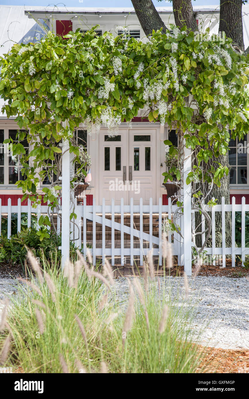 Beach house with picket fence and arbor covered in white wisteria. Old Naples, Florida. Stock Photo