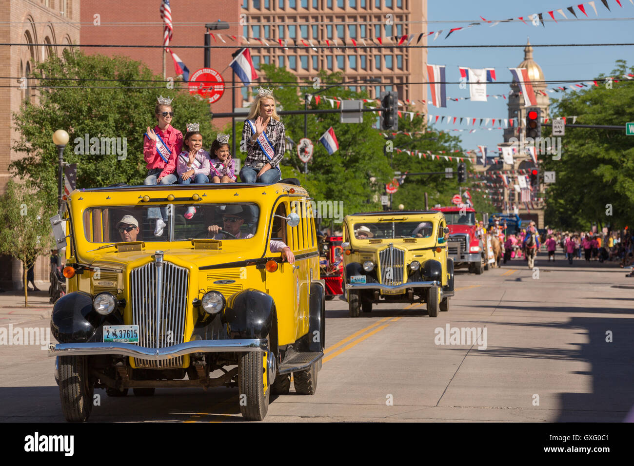 Beauty Queens wave from old buses during the Cheyenne Frontier Days parade past the state capital building July 23, 2015 in Cheyenne, Wyoming. Frontier Days celebrates the cowboy traditions of the west with a rodeo, parade and fair. Stock Photo
