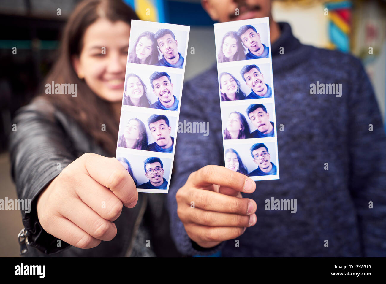 Couple showing photograph strips from photo booth Stock Photo