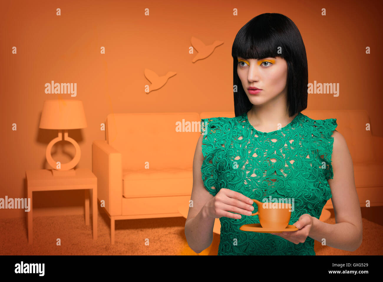 Caucasian woman in orange old-fashioned livingroom drinking coffee Stock Photo
