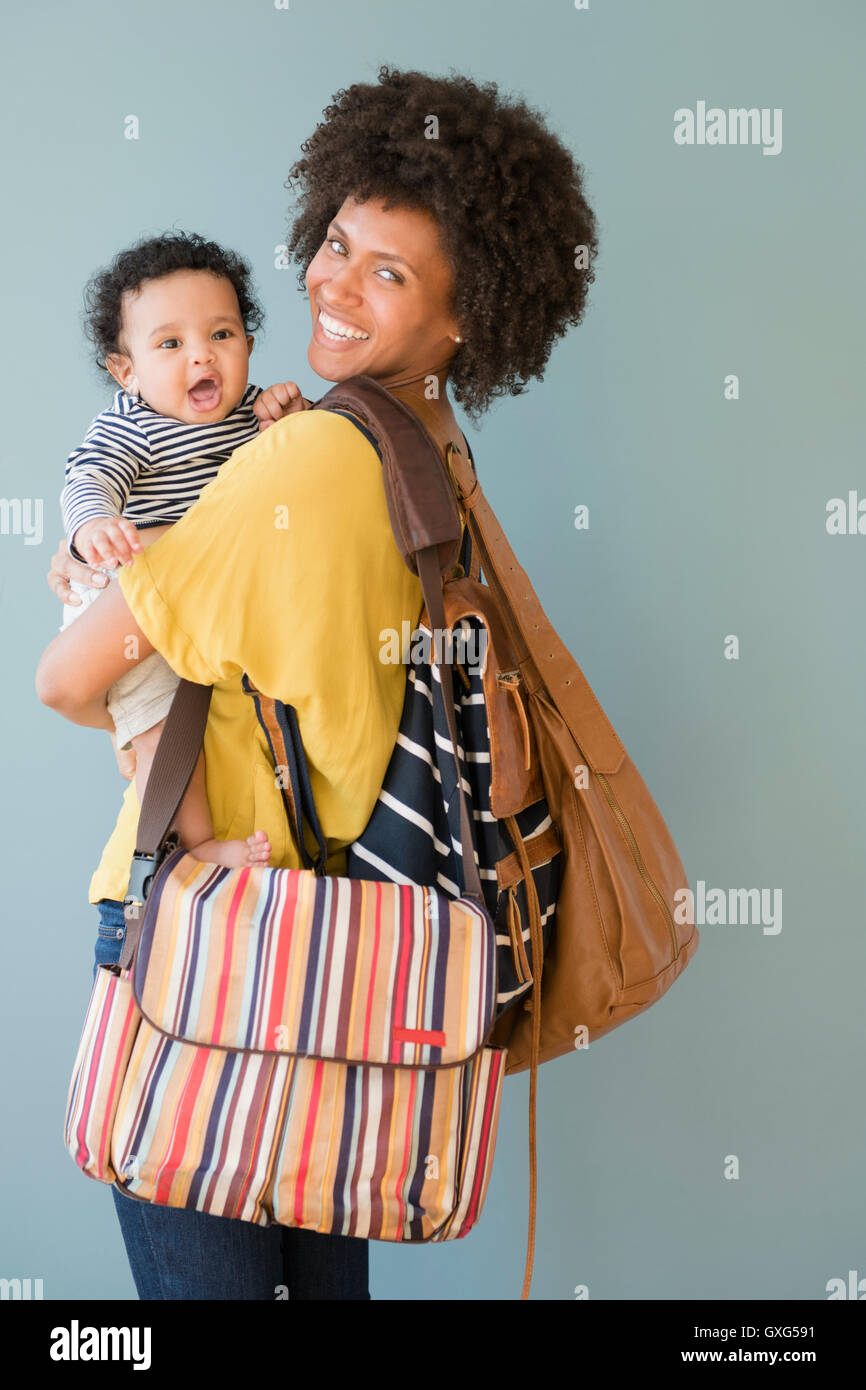 Mother carrying three bags and baby son Stock Photo