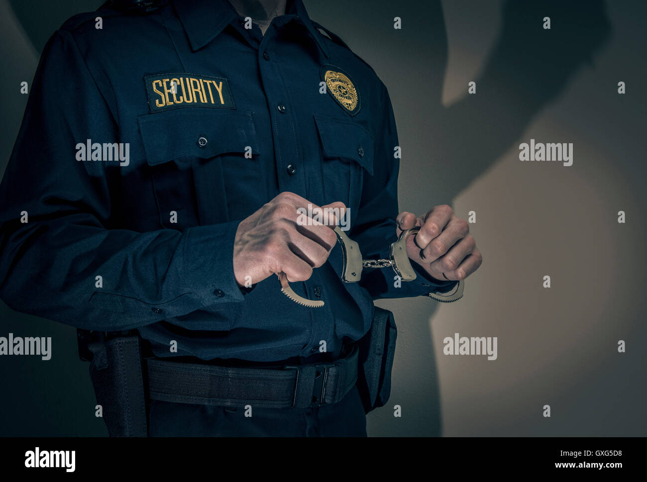 Caucasian security officer holding handcuffs Stock Photo