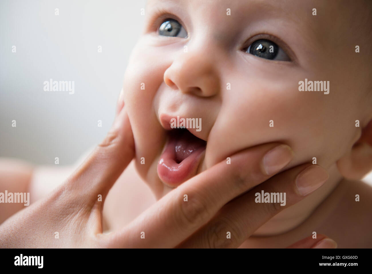 Hand of mother squeezing cheeks of baby son Stock Photo Alamy