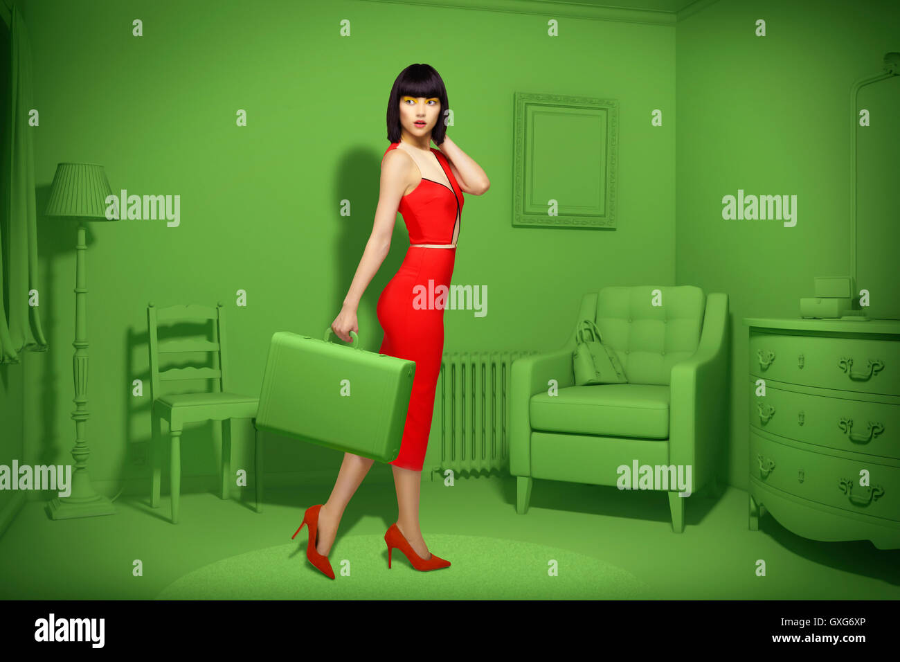 Caucasian woman in green old-fashioned bedroom carrying suitcase Stock Photo