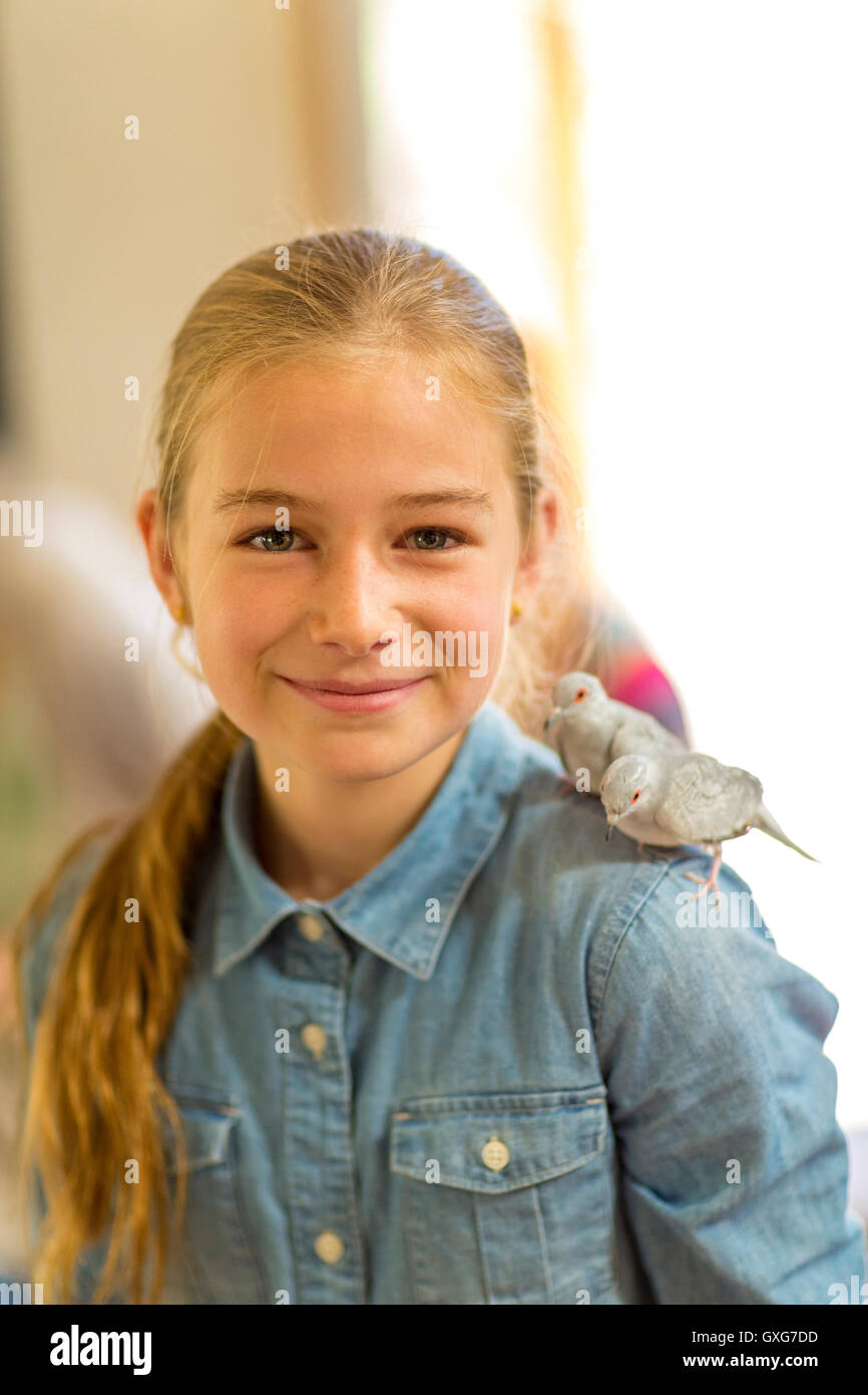 Caucasian girl with two pet birds standing on shoulder Stock Photo Alamy