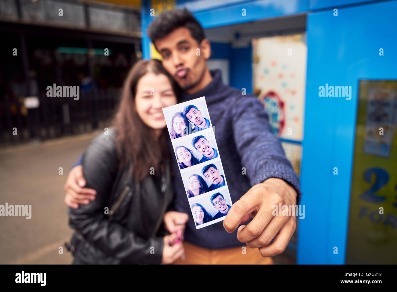 Couple showing photograph strip from photo booth Stock Photo