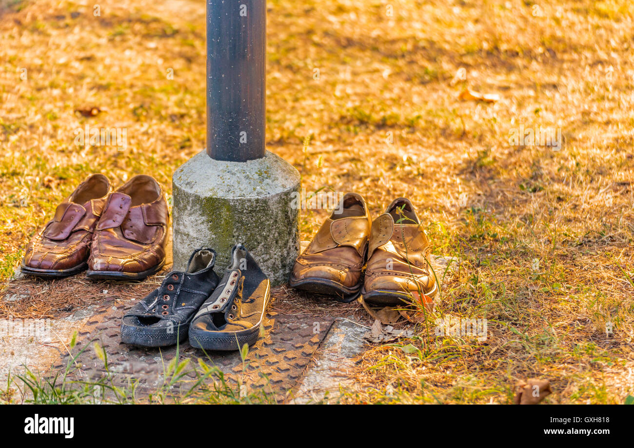 shoes of bums accurately aligned under a streetlight Stock Photo