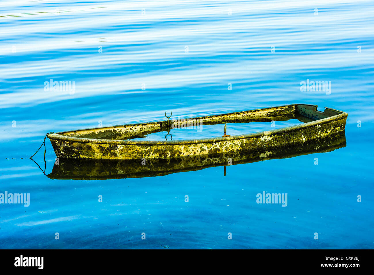 Small abandoned boat almost completely submerged in the seawater. Stock Photo