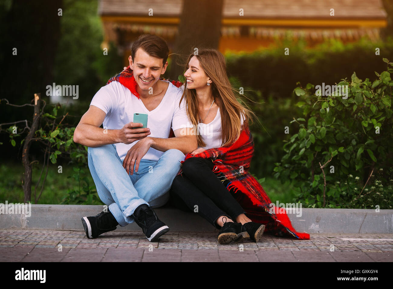 Beautiful young couple relaxing in the park Stock Photo - Alamy