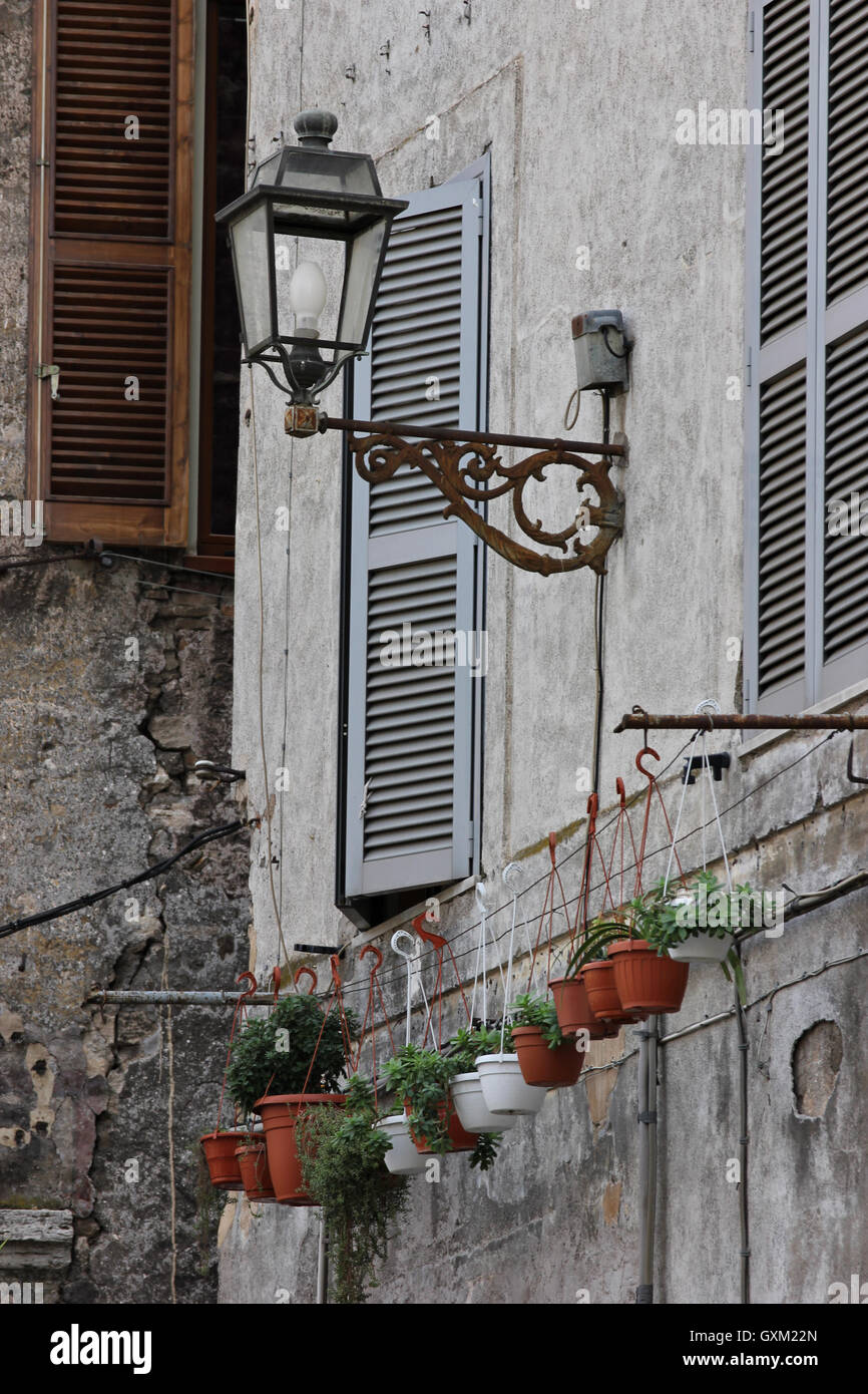 a view full of character of an old building in tivoli, old lampost, flower pots, shutters, Italy Stock Photo