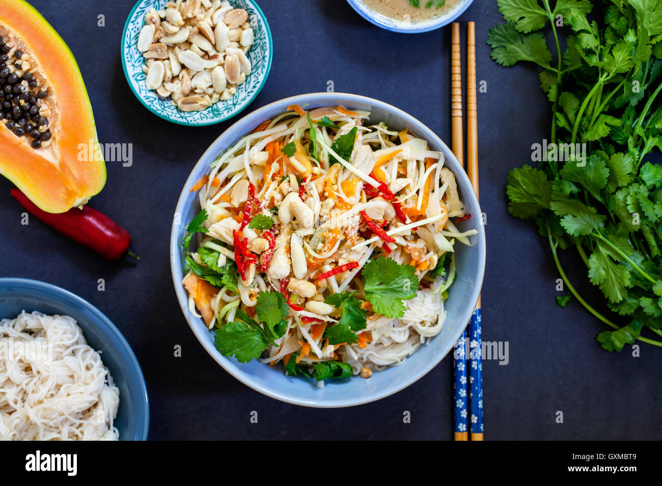 Poached chicken, cabbage and papaya salad with rice noodles and coriander Stock Photo Alamy