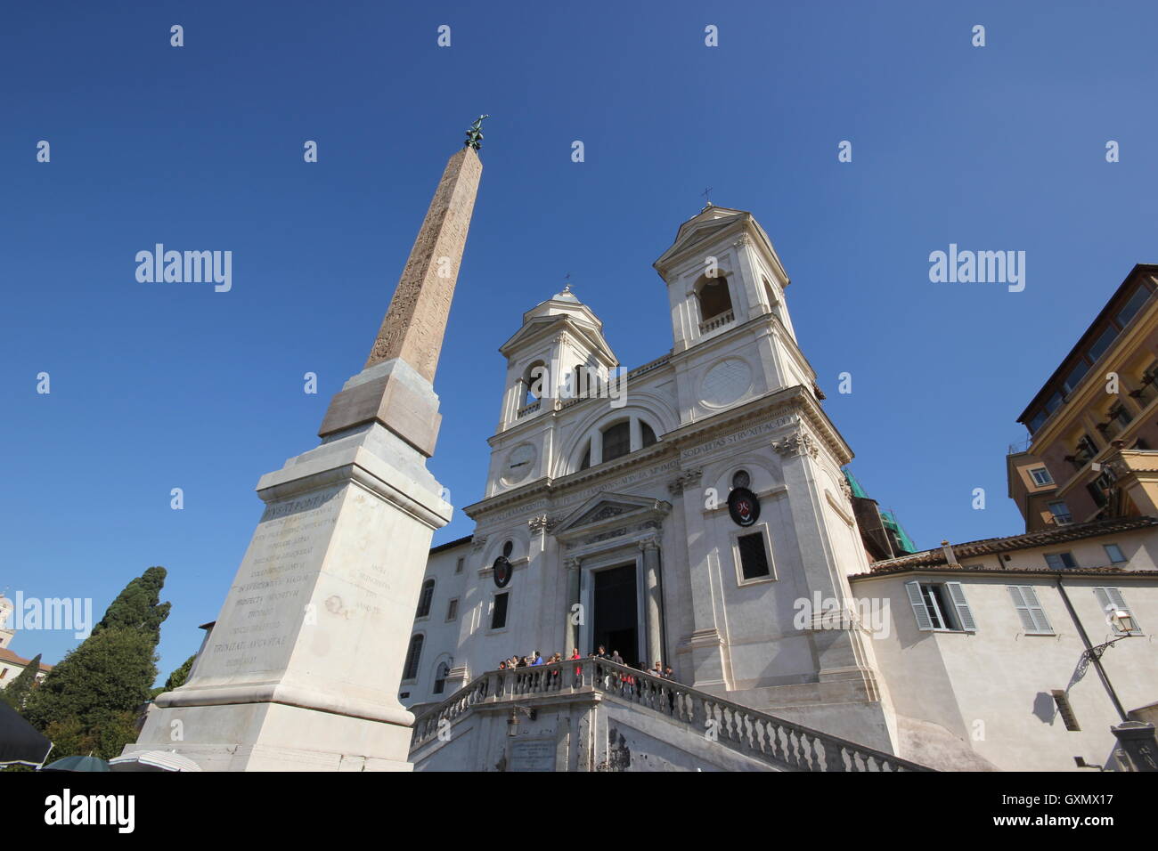 An extraordinary wide angle view of the obelisk & the Church of Trinità dei Monti, with a clear blue sky, tourists, Roma, Rome Stock Photo