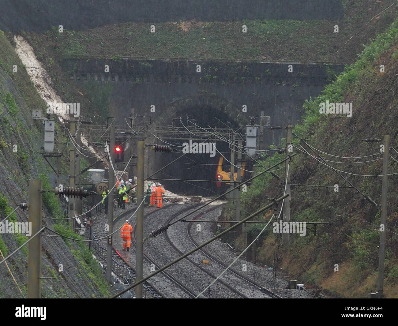 Rescue workers at the scene of the railway accident at Hunton Bridge tunnel near Watford Junction. Getting ready to clear the train from the tunnel, standing by the landslip at the entrance. Wet weather. Stock Photo