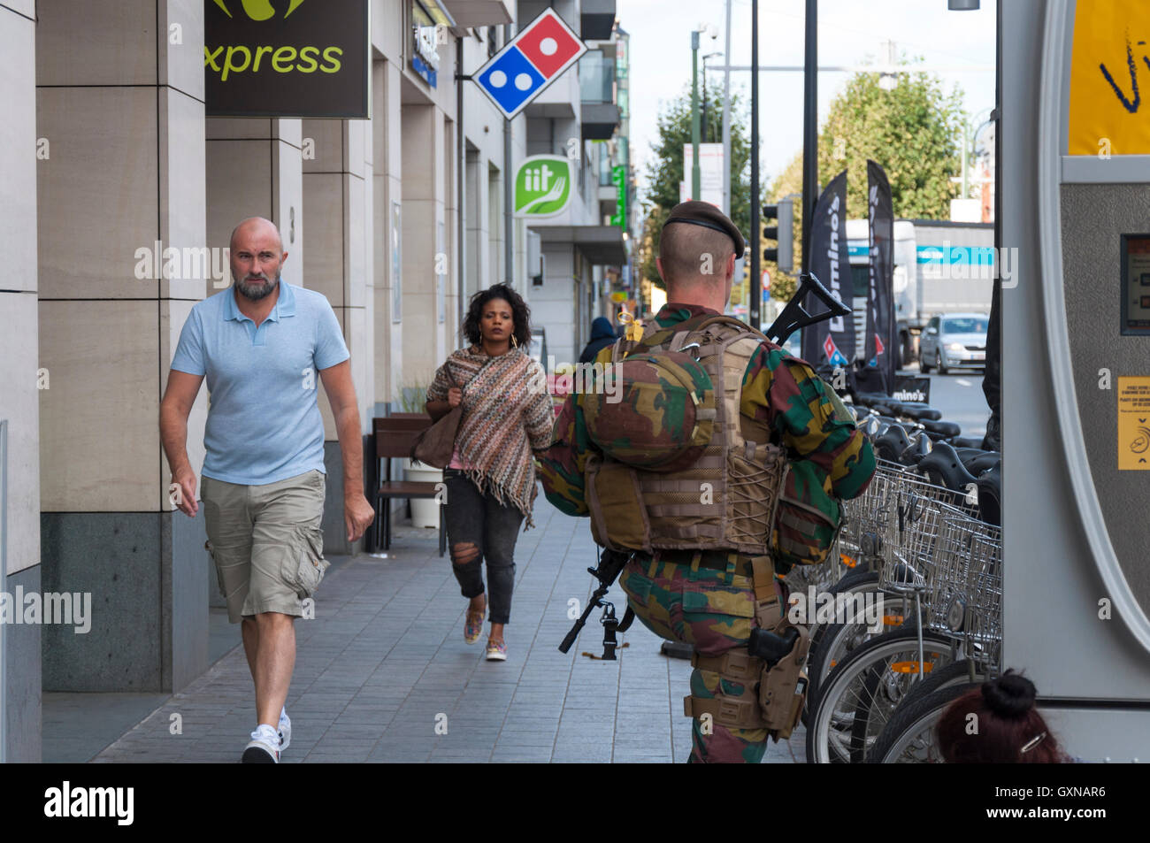 Brussels, Belgium. 16th September 2016. Belgian army patrols the centre of the capital. The high visibilty army patrols are as much to reassure the general public as to deter terrorists. A  pedestrian glances at a patrolling soldier. Credit:  Richard Wayman/Alamy Live News Stock Photo