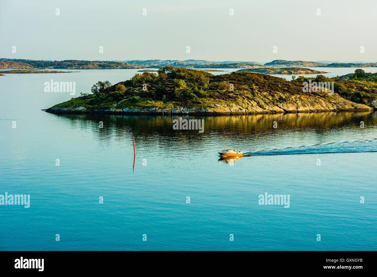 Small motorboat moving slowly through windless sea in the Swedish west coast archipelago. Stock Photo