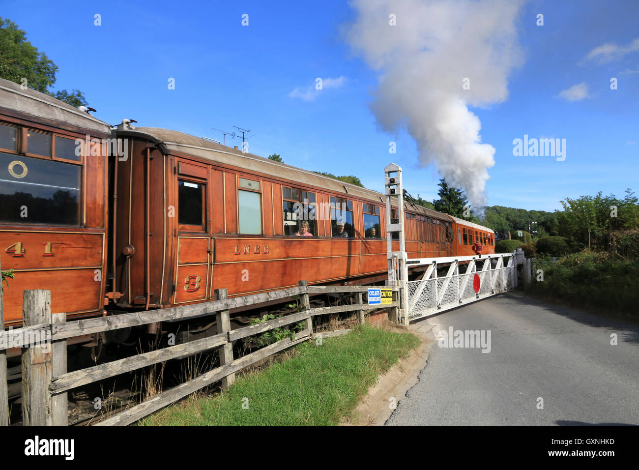 Train with steam locomotive heading to Whitby on the North York Moors Railway, passing through Newbridge. Stock Photo