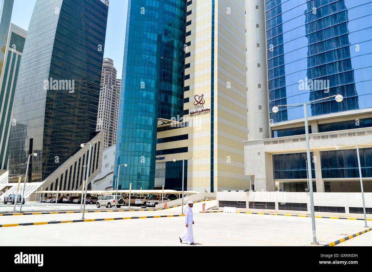 Qatari man walking in the high rise buildings district of Doha, Qatar Stock Photo
