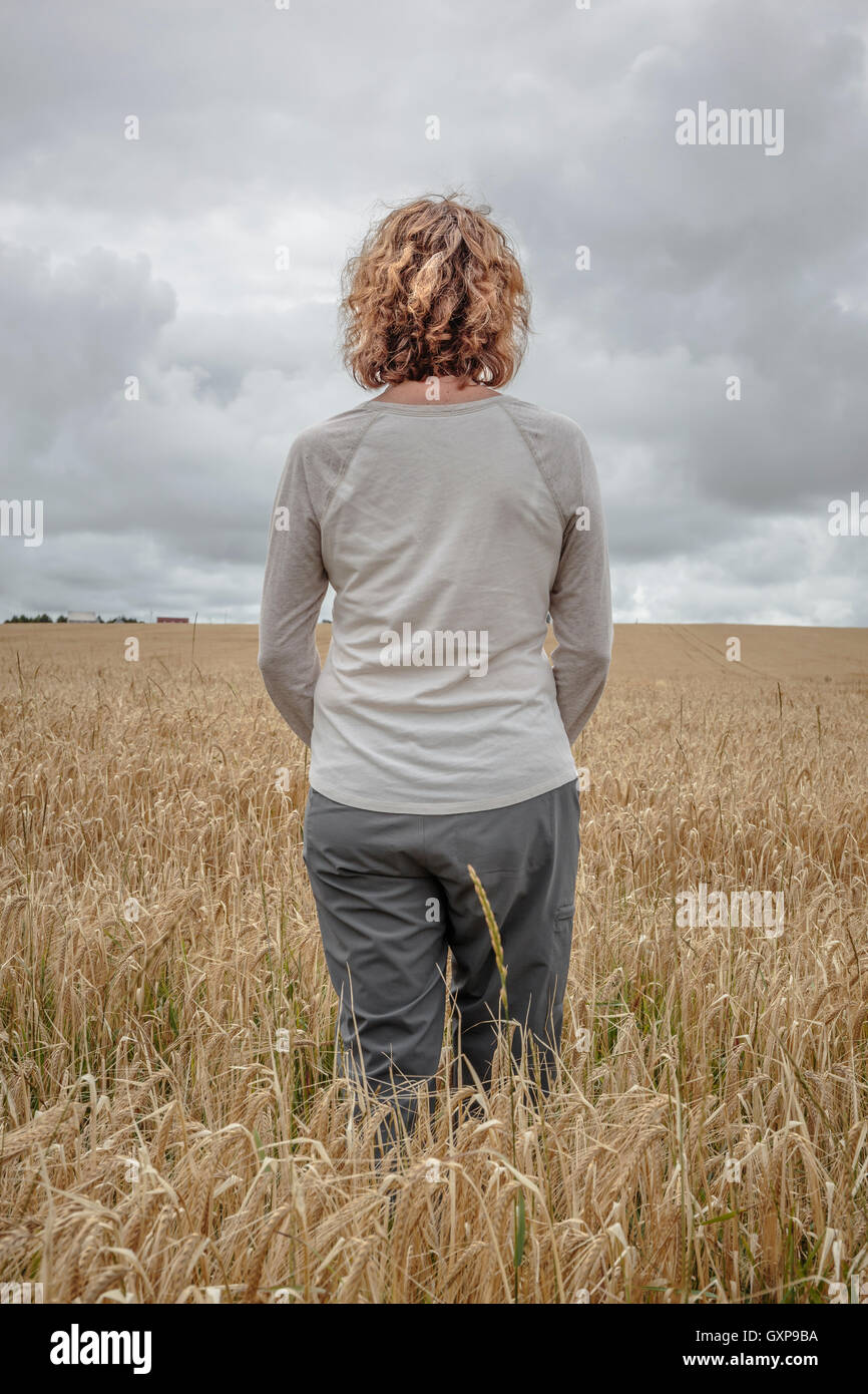 A woman standing in a wheat field, Prince Edward Island, Canada. Stock Photo