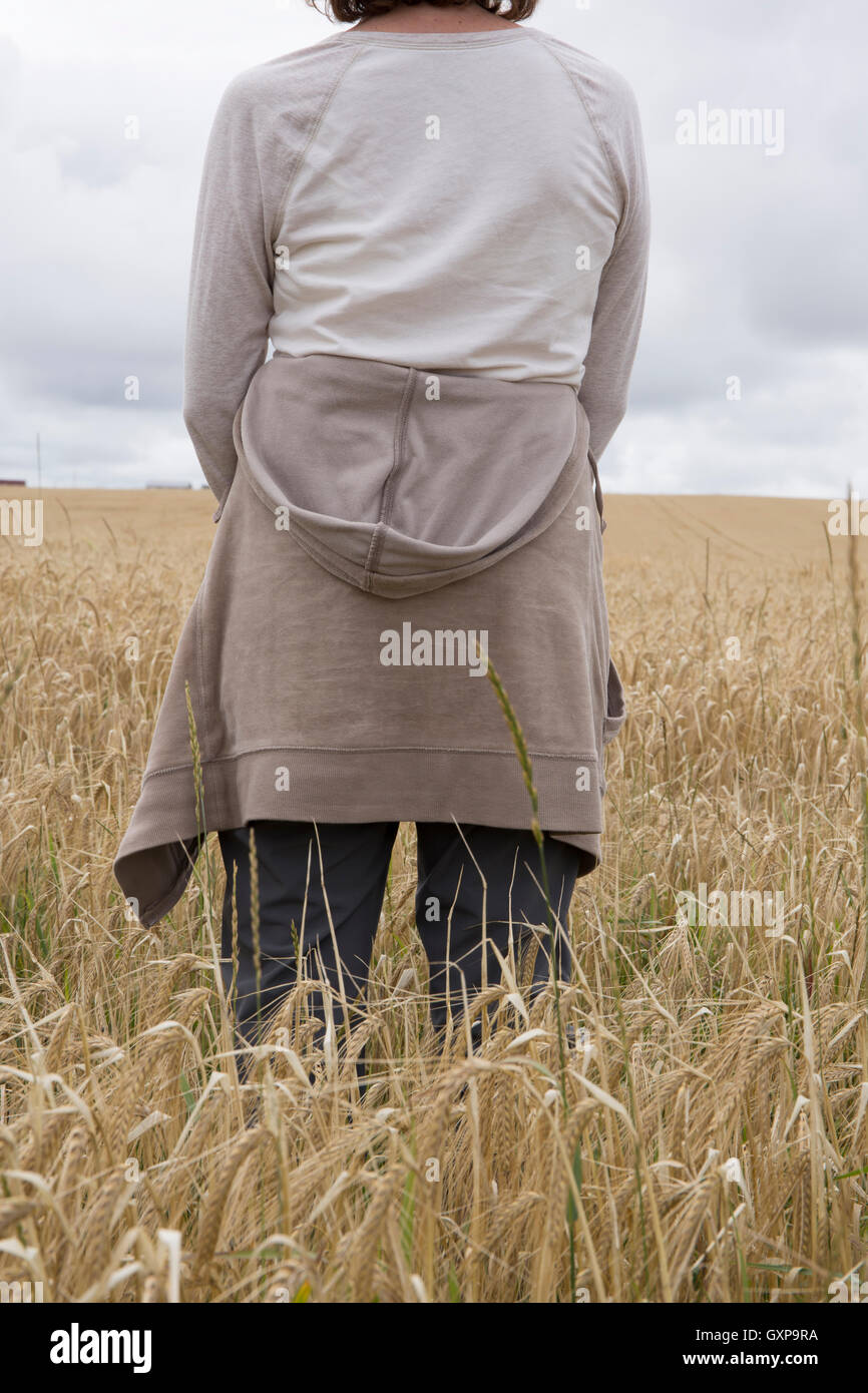 A woman standing in a wheat field, Prince Edward Island, Canada. Stock Photo