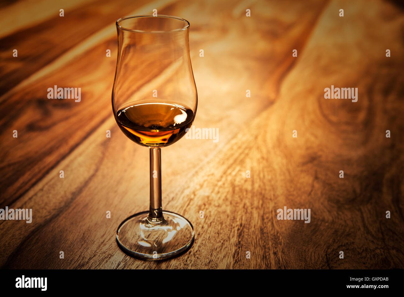 Nosing glass with scotch single malt whisky on the old wooden table Stock Photo