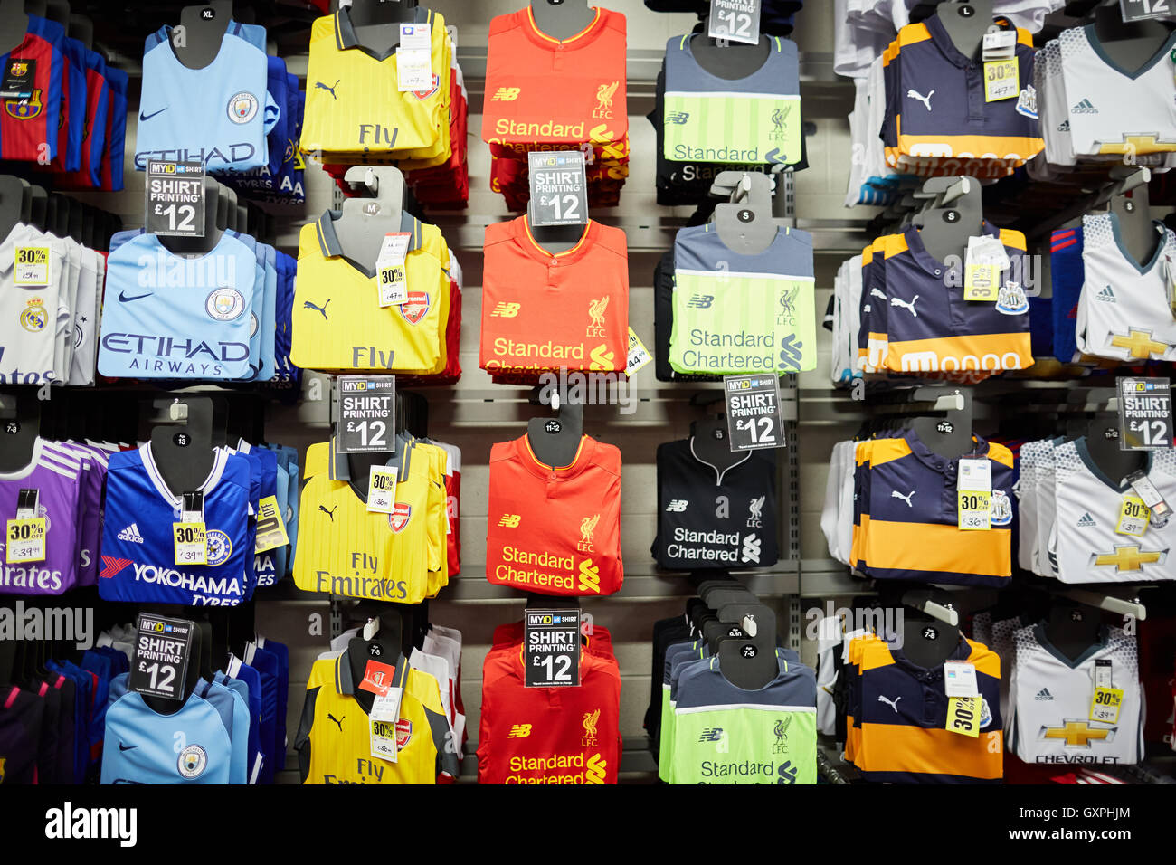 Sports direct football shirts shop   display premiership team official replica shirts tops strip wall display to buy Arsenal Liv Stock Photo