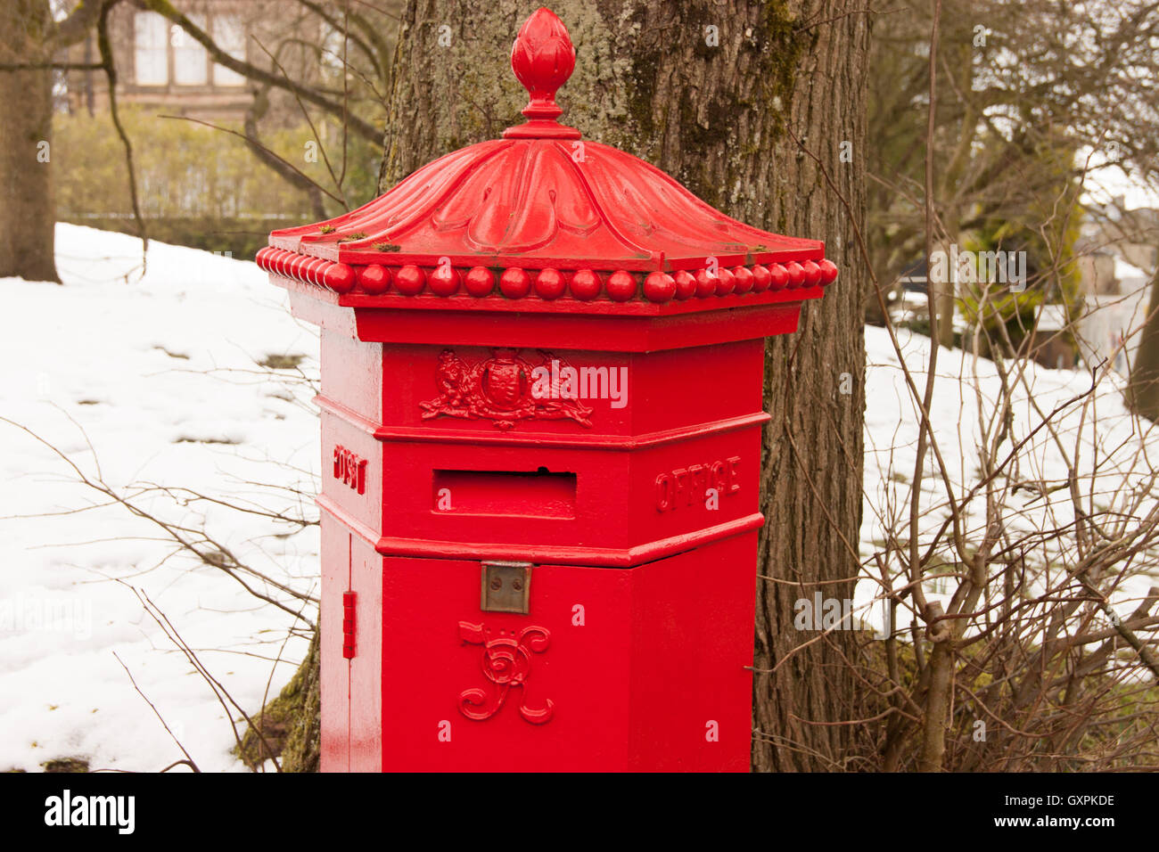 Red pillar box post box in snowy peak district, festive snow Buxton Derbyshire Stock Photo