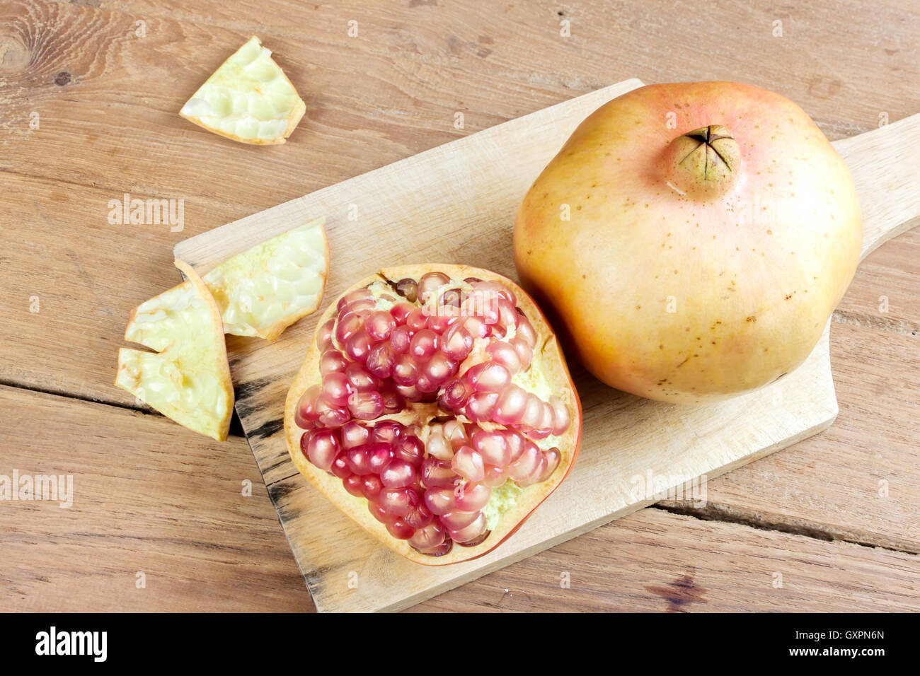 Pomegranate fruit cut dissect on wooden background. Stock Photo