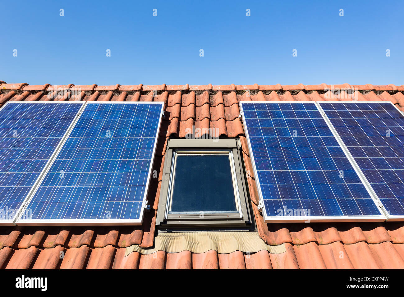 Solar panels and attic window with blue sky Stock Photo