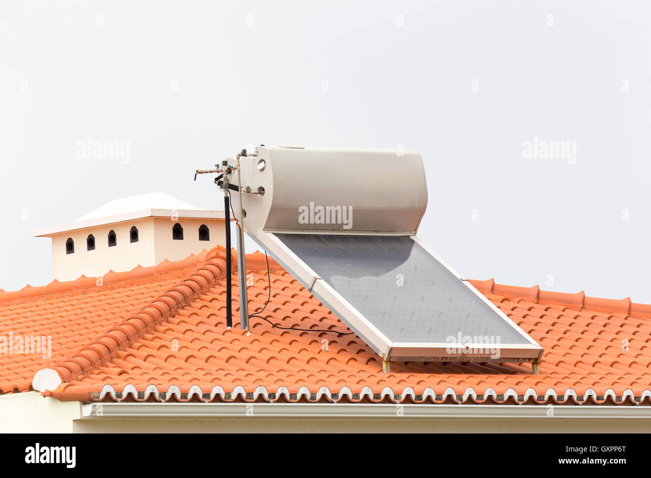 Hot water boiler with solar panel on roof of house Stock Photo