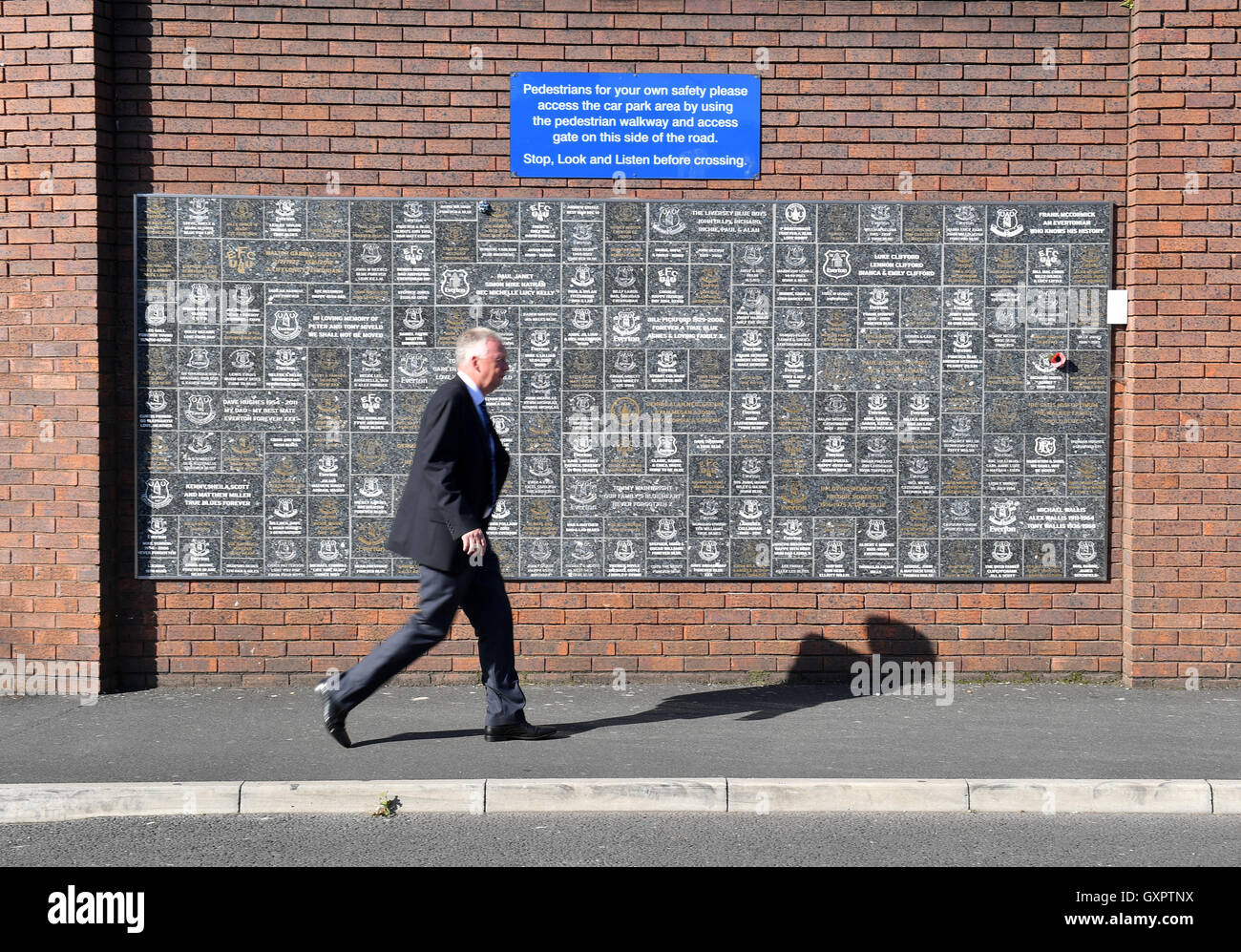 A pedestrian walks past the Dixie Dean Wall of Fame prior to the Premier League match at Goodison Park, Liverpool. Stock Photo