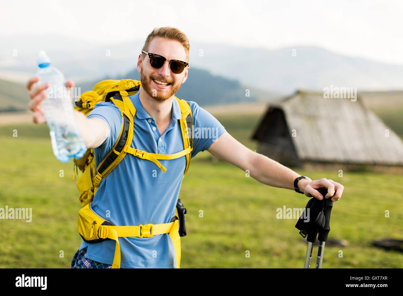 Young hiker stopped and drink water from a bottle Stock Photo