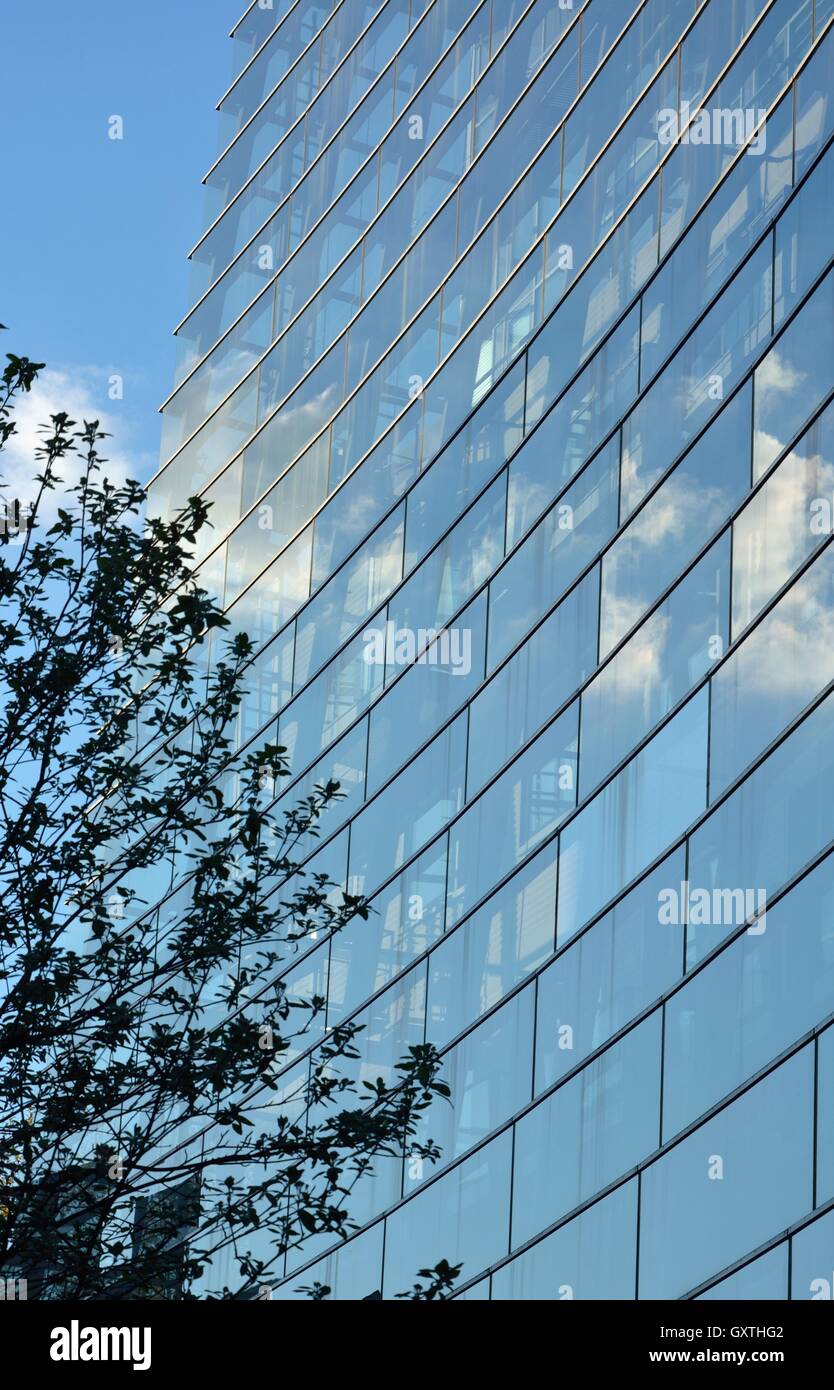 Detail of glass facade of modern office building with reflection of ...