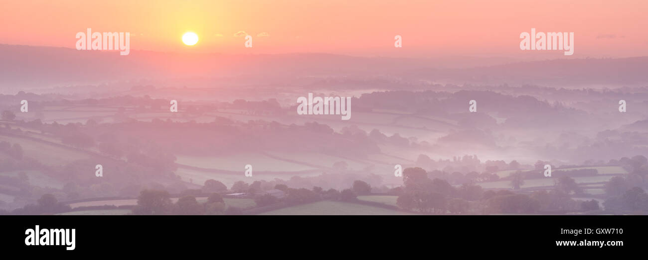 Sunrise over mist covered rolling countryside, Dartmoor, Devon, England. Autumn (October) 2015. Stock Photo