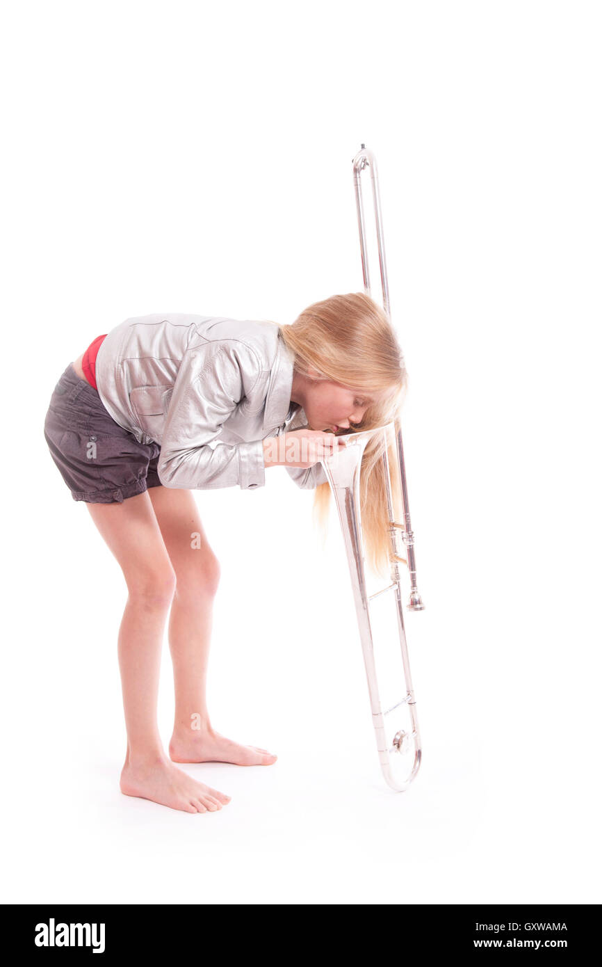 young girl in silver jacket looking into her trombone Stock Photo